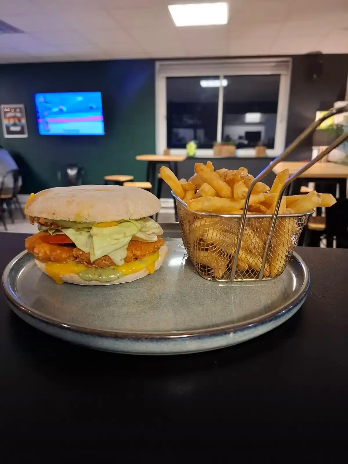Burger Le Chiquita avec frites servi au bar/snack de l’Arène Cahors.