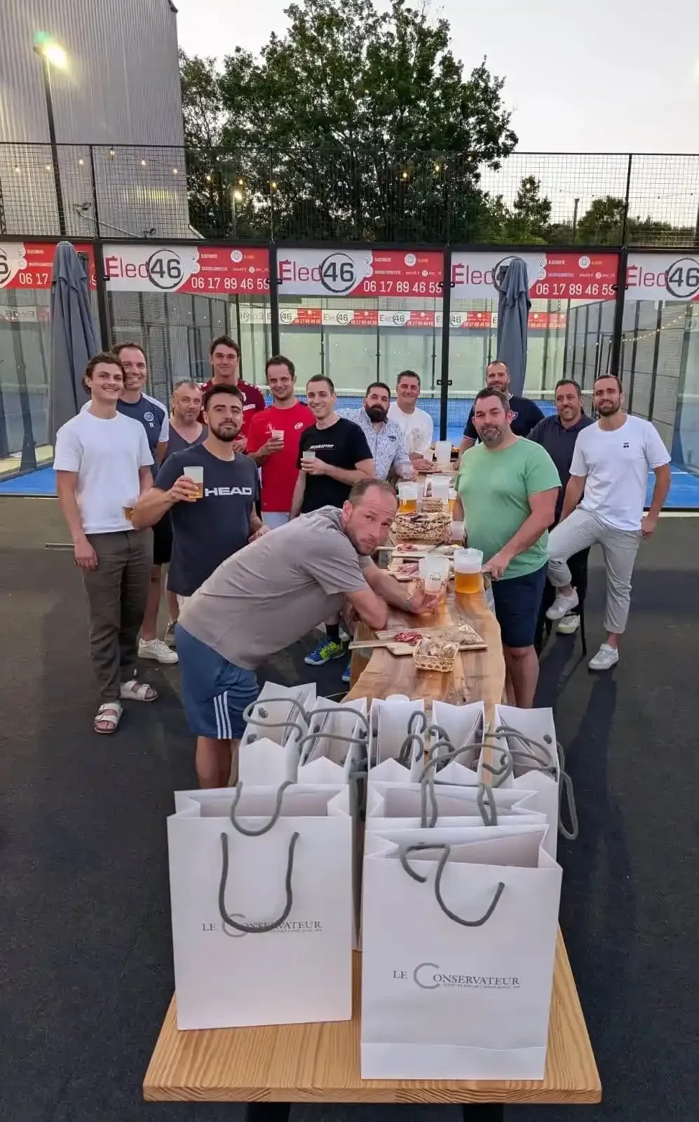 Groupe de joueurs de padel réunis autour d’une table pour un moment convivial à l’Arène Cahors.